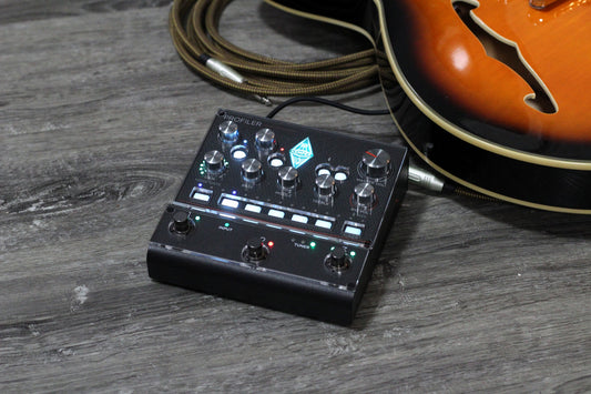 Kemper Profiler Player with the clear ProtectYourGear acrylic cover, guitar in the background